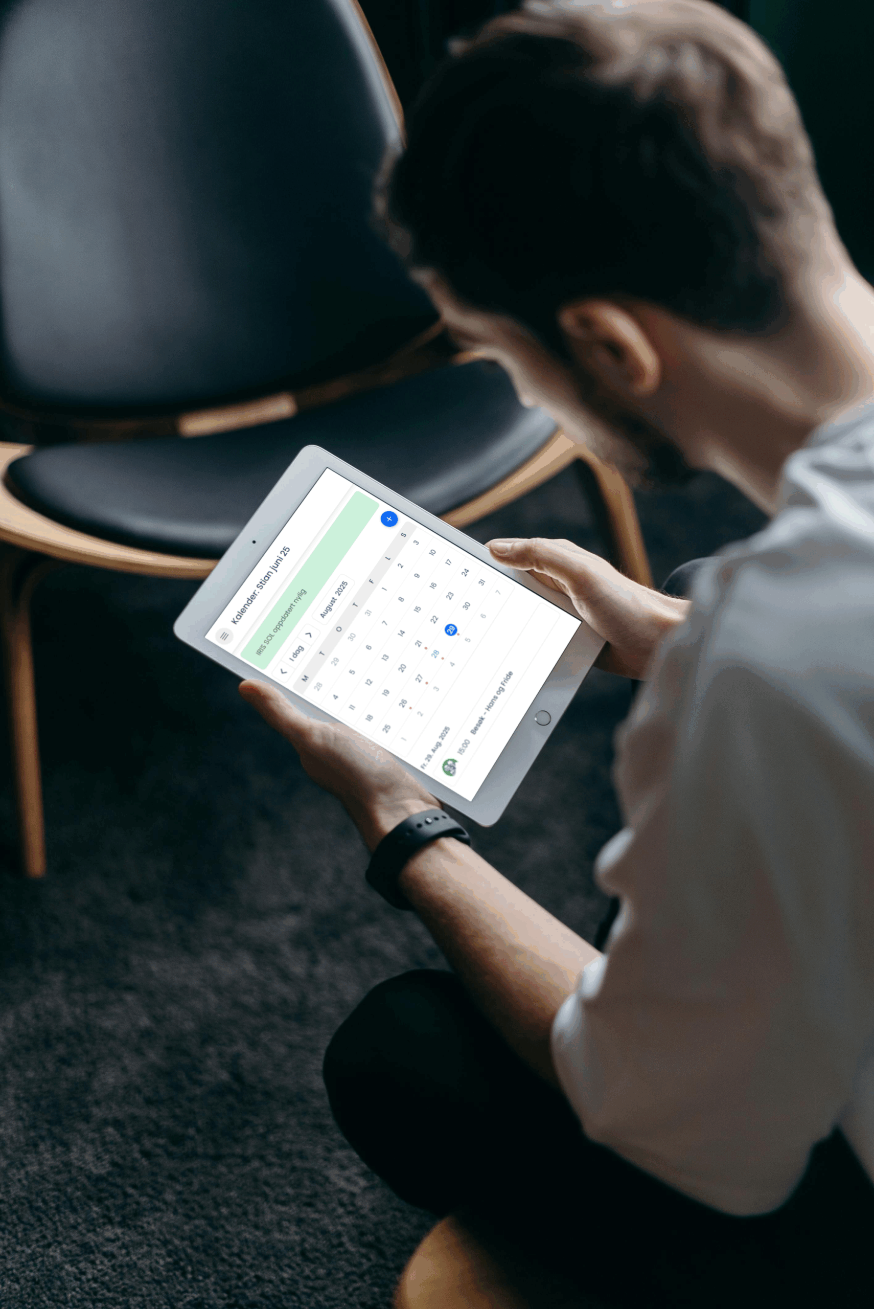 En mann som sitter og administrerer en kalender via SOL Portal på et nettbrett